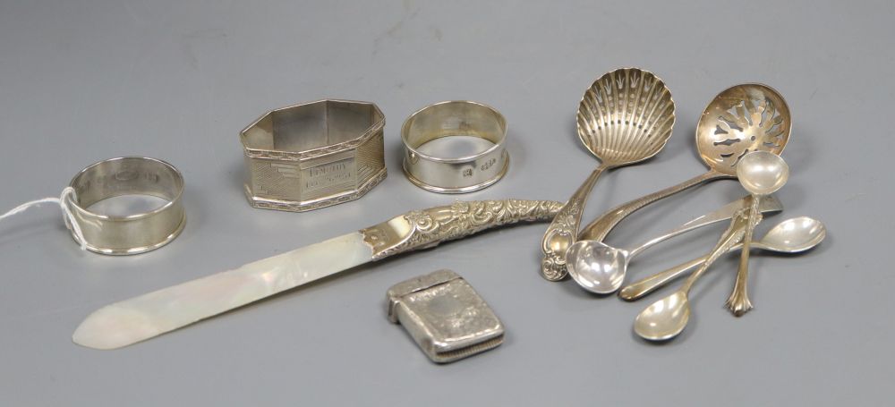 Three silver napkin rings, a silver vesta case, a silver handled letter opener and items of small flatware.